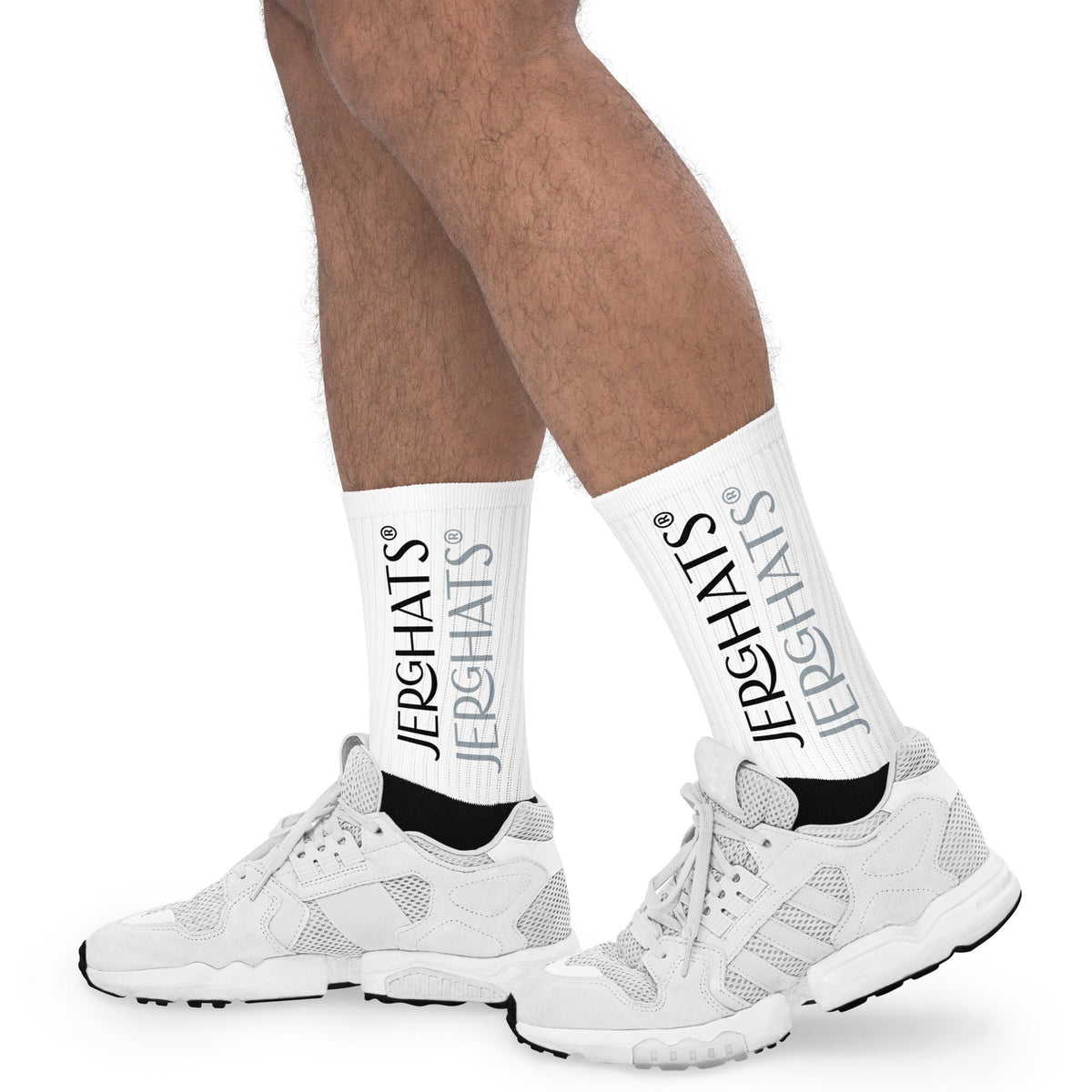 JERGHATS crew socks with white ribbed leg, black foot, and branded logo print worn with white athletic sneakers.